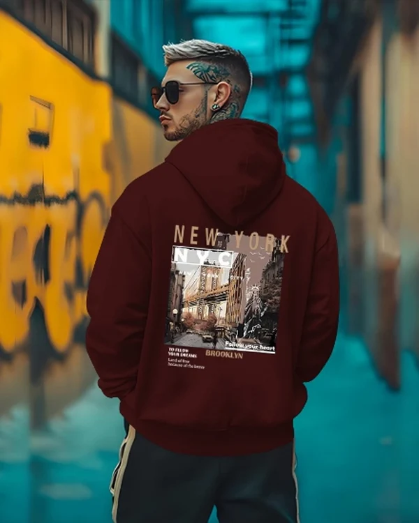 Back Printed Maroon Essential Hoodie with premium cotton fleece fabric, oversized fit, stylish graphic back print, kangaroo pocket, adjustable hood, and ribbed cuffs on a clean white background.